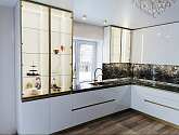 Элегантная классическая кухня для частного дома со стеклянными шкафами, линейной подсветкой и встроенной техникой