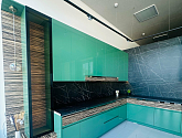 Зеленая глянцевая кухня с темной столешницей
