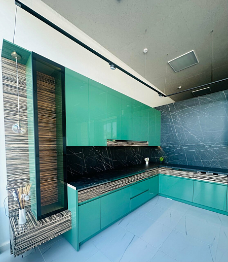 Зеленая глянцевая кухня с темной столешницей фото 1