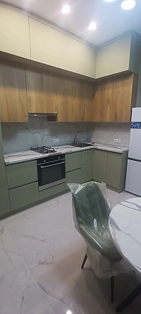 Угловая зеленая кухня с мдф фасадами и шпонированными вставками фото 2