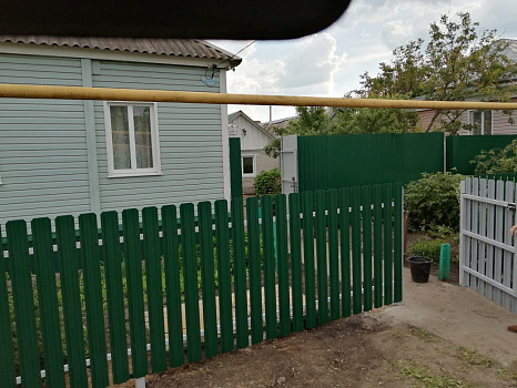 Забор из зеленого евроштакетника с односторонней зашивкой фото