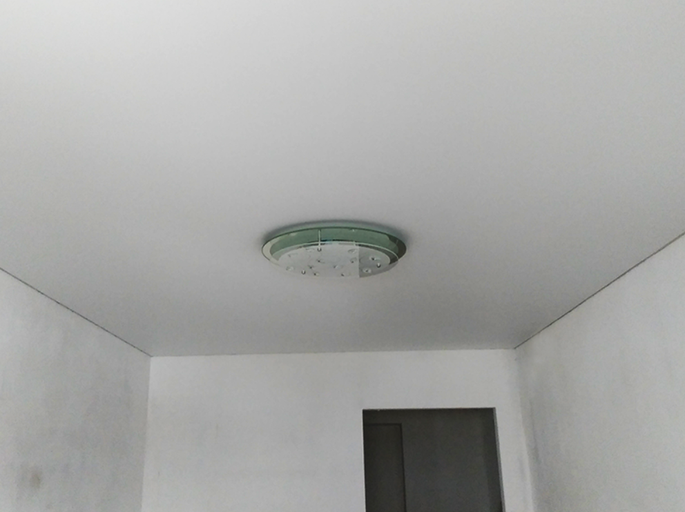 Натяжной потолок со встроенными спотами и люстрой в спальне площадью 24 кв. м. фото