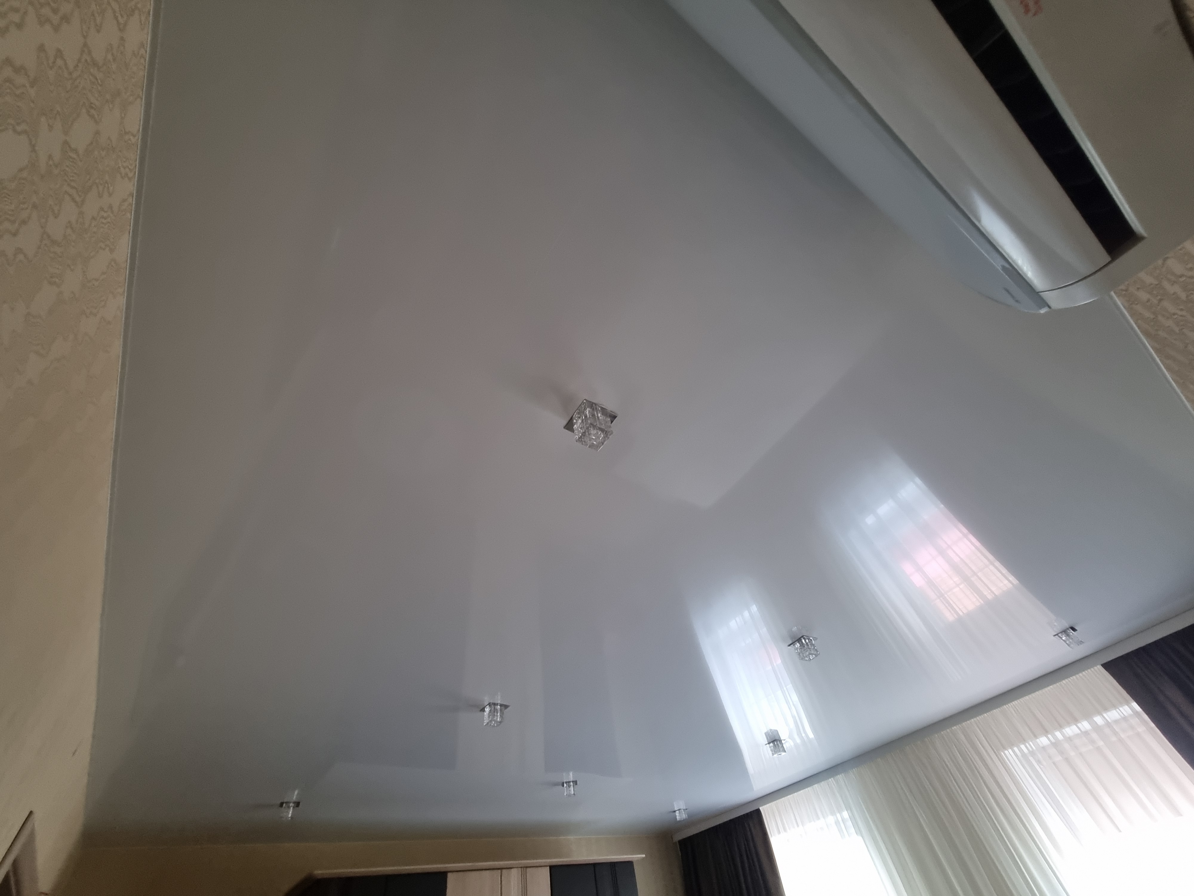 Глянцевый натяжной потолок в большой спальне фото