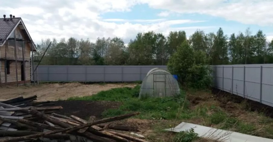 Забор из одностороннего профнастила по периметру участка на столбах, выполненных методом бутования фото