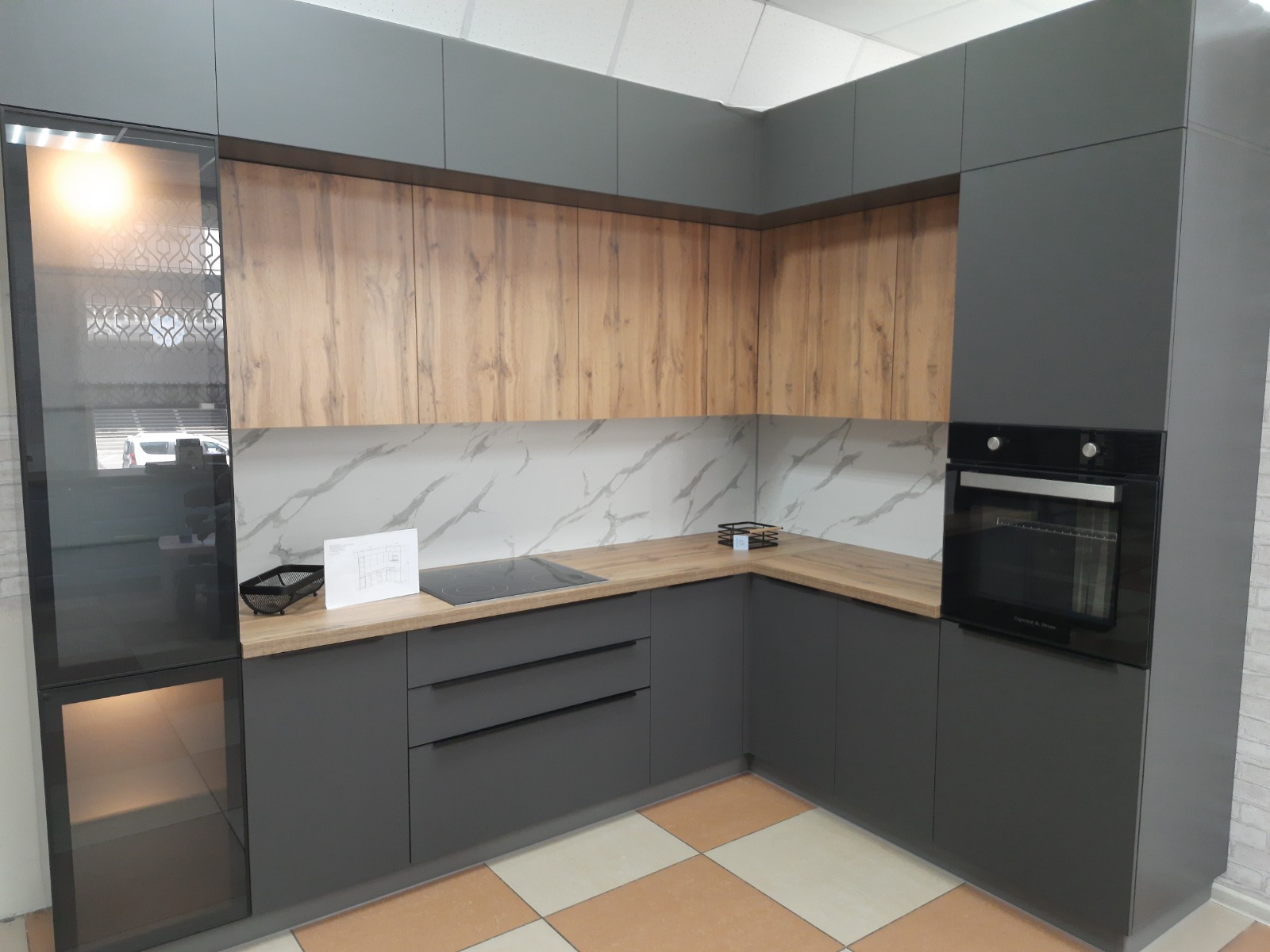 Кухонный гарнитур в стиле современного модерна, в темных тонах и со стеклянной тонированной витриной фото